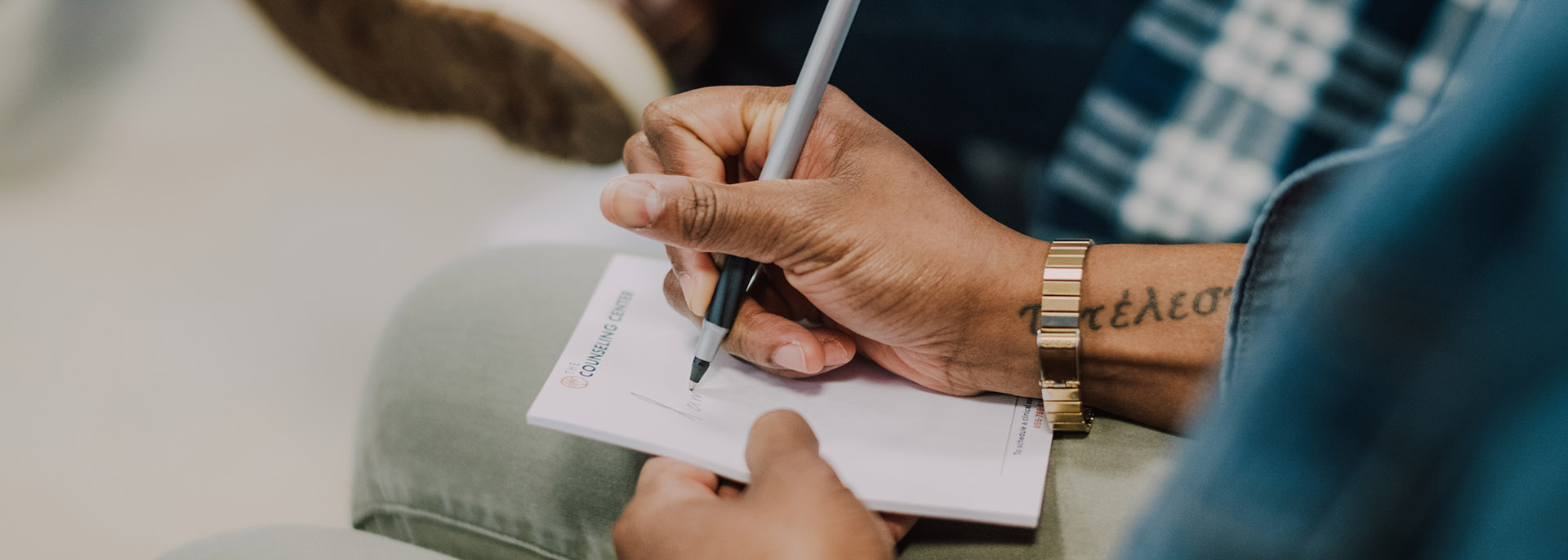 a man writing notes in a group session at Middlesex