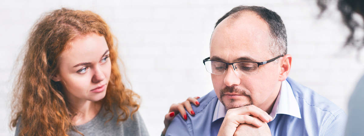  Supportive wife comforting husband with TRD during a meeting with a counselor in Middlesex.