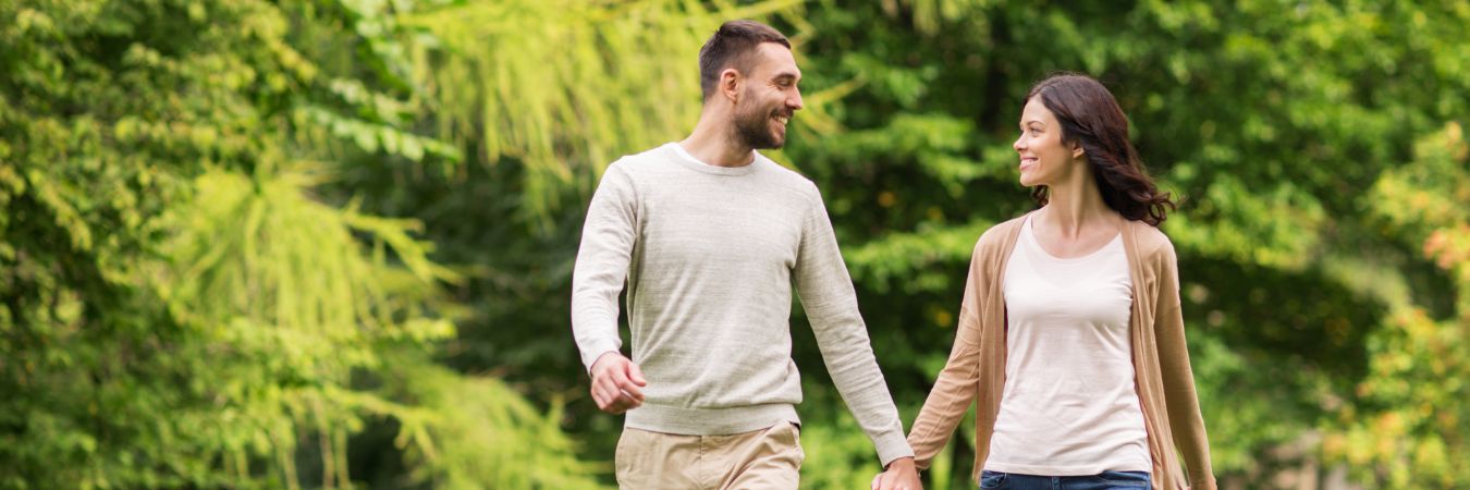 A couple walking hand in hand at a park during summer season enjoying life after rehab in Middlesex